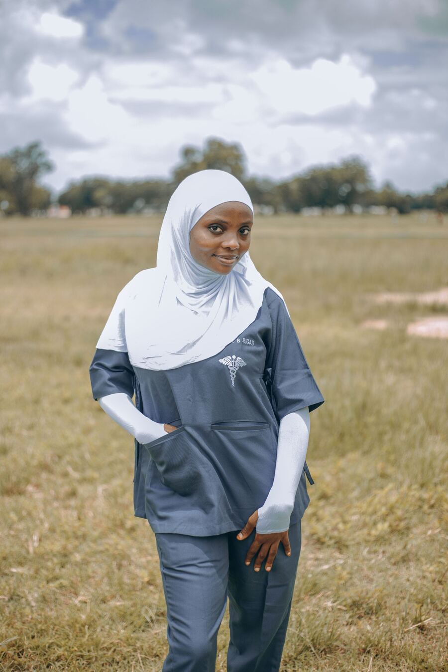 A smiling care worker in a hijab and scrubs