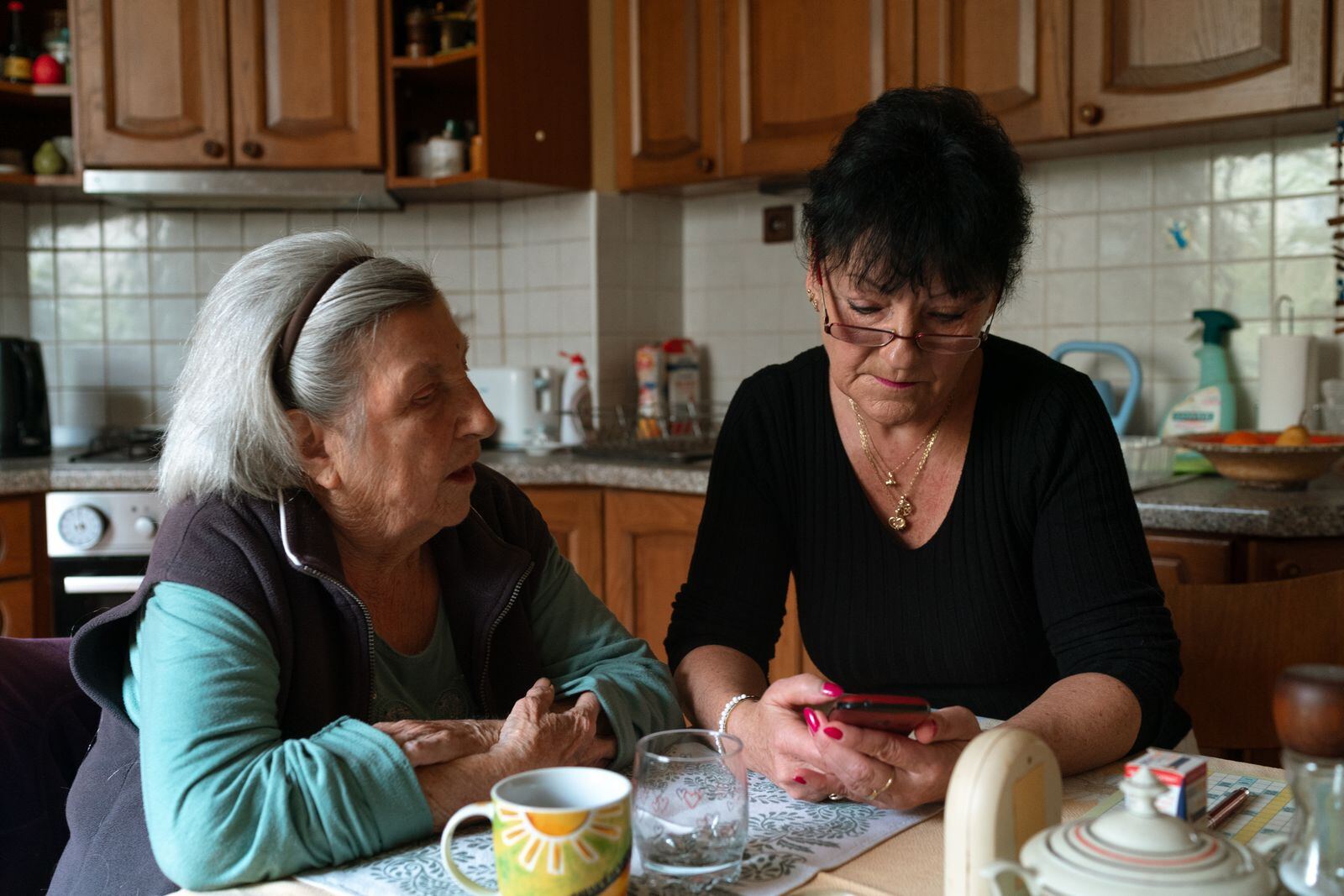 A care worker talking things through with an older woman at her kitchen table